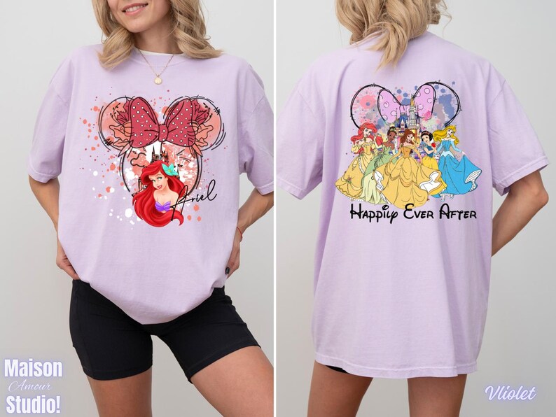May include: A light purple t-shirt featuring a Minnie Mouse-inspired design with Ariel from The Little Mermaid on the front. The back of the shirt displays Disney princesses with the text "Happily Ever After". The shirt is a comfortable, oversized fit.
