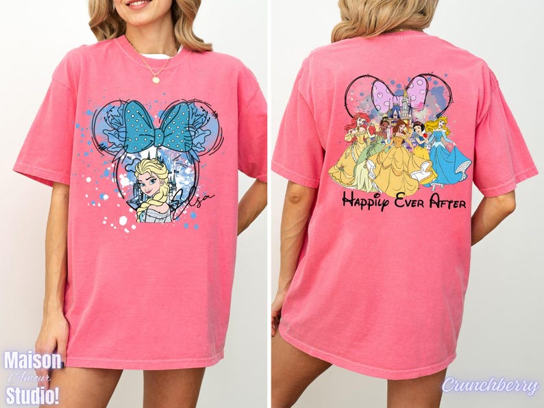 Pode incluir: T-shirt rosa com um desenho animado de Elsa e um la&ccedil;o azul. A parte de tr&aacute;s da camisa apresenta princesas da Disney e as palavras "Happily Ever After".