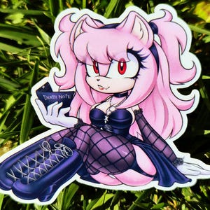 May include: A sticker featuring a pink hedgehog-like character with red eyes, holding a book labeled "Death Note." The character wears a black choker, a low-cut top, and fishnet stockings. The overall design has a gothic anime aesthetic.