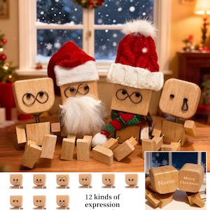 Peut inclure: Figurines en blocs de bois avec des visages interchangeables, portant des bonnets et des écharpes de Père Noël. Les figurines ont des yeux en forme de symbole infini et sont accompagnées de blocs avec diverses expressions et le texte "12 kinds of expression".