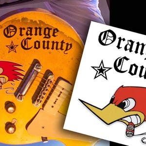 May include: A yellow electric guitar with a black and white "Orange County" sticker and a cartoon roadrunner sticker. The guitar has a white pickguard and chrome hardware.