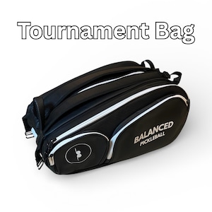 Peut inclure: Sac de tournoi de pickleball noir avec des détails blancs et le texte "Tournament Bag". Le sac a un compartiment zippé et les mots "BALANCED PICKLEBALL" sont imprimés sur le côté.