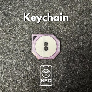 May include: A purple keychain with a white circle and black musical note symbol. The keychain has a small NFC symbol on the bottom.