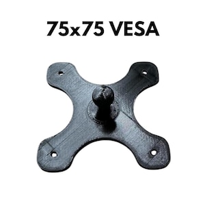Peut inclure: Support mural en plastique noir VESA 75x75 avec quatre trous de vis et une rotule au centre.