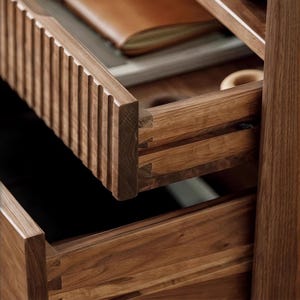 Puede incluir: Primer plano de dos cajones de madera con un dise&ntilde;o detallado e intrincado. El caj&oacute;n superior est&aacute; abierto, revelando un interior oscuro. Los cajones est&aacute;n hechos de una madera rica y oscura con veta natural.