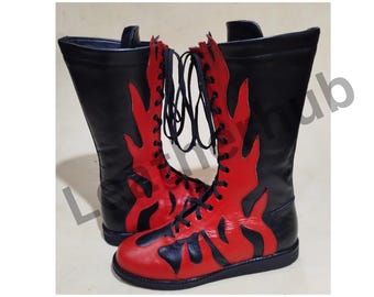 May include: A pair of black leather wrestling boots with red flame designs. The boots have laces and are tied up.