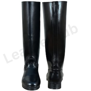 May include: A pair of black leather riding boots. The boots are knee-high with a polished finish. They feature a classic design with a small heel. The boots are suitable for equestrian activities or general wear. The boots are made of leather.