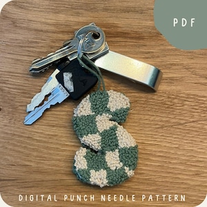 Peut inclure: Un porte-clés en forme de S, vert et beige à motif de damier, avec des clés attachées. Le texte "DIGITAL PUNCH NEEDLE PATTERN" est en bas de l'image, et "PDF" est en haut à droite.