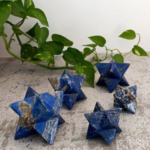 Pode incluir: Cinco pontas de cristal em forma de estrela de lapis-lazúli azul e dourado de tamanhos diferentes.