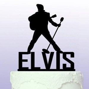 Könnte beinhalten: Schwarze Silhouette von Elvis Presley, der ein Mikrofon und eine Gitarre hält, mit dem Wort "ELVIS" darunter. Dies ist ein Tortendekor.
