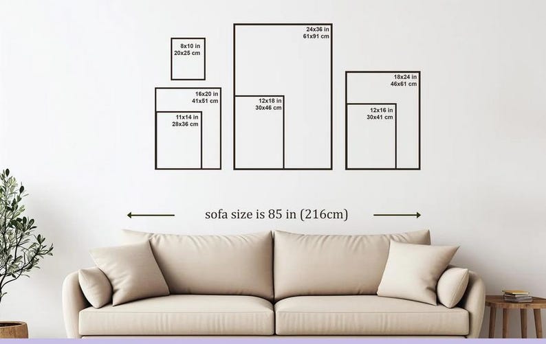 Op de afbeelding: Een beige bank van 216 cm breed onder een wandpresentatie van zwarte rechthoekige kaders. De kaders zijn gelabeld met afmetingen zoals 20x25 cm, 28x36 cm, 30x41 cm, 30x46 cm, 41x51 cm, 46x61 cm en 61x91 cm, inclusief de imperiale equivalenten.