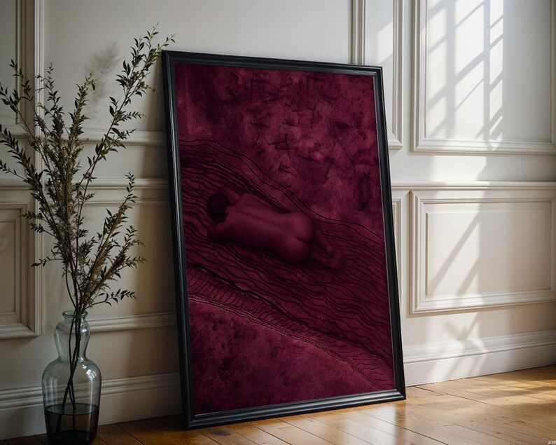 Op de afbeelding: Een ingelijste verticale kunstprint met een diep bordeauxrode en kastanjebruine kleurenpalet. Het kunstwerk toont een menselijk figuur liggend op een gestructureerd oppervlak met donkere, golvende lijnpatronen en abstracte vormen.