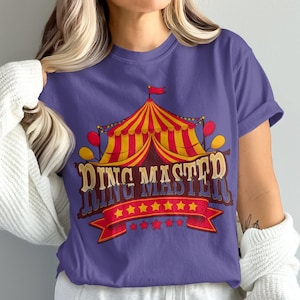 Może przedstawiać: Fioletowy T-shirt z grafiką namiotu cyrkowego i tekstem "Ring Master" w stylu vintage.
