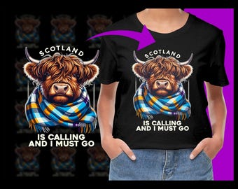 May include: Black t-shirt with a cartoon Highland cow wearing a blue and yellow plaid scarf. The text "Scotland is calling and I must go" is printed on the shirt.