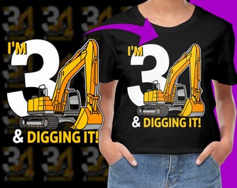 May include: A black t-shirt featuring a white number 3 and a yellow excavator graphic. The text "I'm 3 & Digging It!" is printed on the shirt.