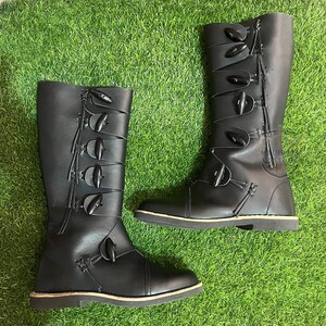 Side profile of brown leather medieval boots with buckle accents and high shaft for Renaissance costumes