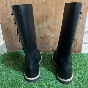 Close-up of black leather Viking boots high ankle design with laces and historical costume detailing