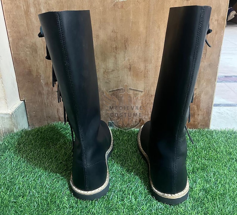 Close-up of black leather Viking boots high ankle design with laces and historical costume detailing