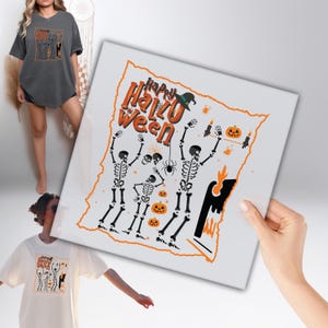 May include: White t-shirt with a Halloween-themed graphic featuring skeletons, pumpkins, and the text "Happy HalloWeen". The design includes a witch's hat, spider, and candles. The image also shows a dark gray t-shirt with a similar design.
