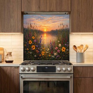 May include: A kitchen backsplash panel featuring a vibrant sunset over a calm lake, surrounded by tall grasses and a variety of colorful wildflowers including yellow, orange, and purple blooms, installed behind a stainless steel gas stove.