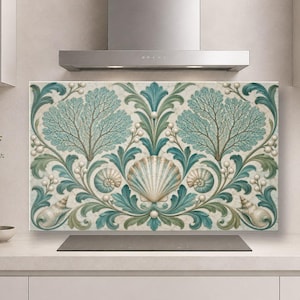 Op de afbeelding: Een rechthoekig keukenachterwandpaneel met een symmetrisch patroon van blauwgroene zeewaaiers, diverse schelpen en kleine witte parelachtige bolletjes tegen een crèmekleurige achtergrond met een subtiele marmerachtige textuur.