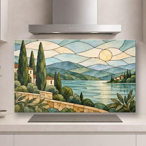 Puede incluir: Un panel rectangular para salpicadero de cocina con una ilustración de paisaje estilo vidriera que muestra un lago, colinas, cipreses altos, muros de piedra y un sol amarillo pálido en un cielo con nubes azul claro y crema.
