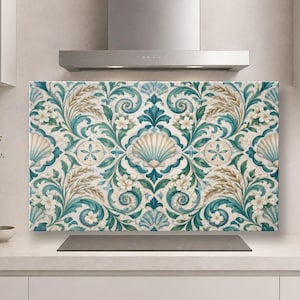 May include: A rectangular kitchen splashback panel featuring a repeating pattern of teal and blue seashells, sand dollars, and white flowers intertwined with swirling green foliage on a cream-coloured background, positioned behind a hob.