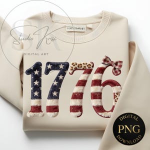 Può includere: Felpa color crema con il numero "1776" in un design patriottico. L'"1" e il "7" sono blu con stelle bianche e stampa leopardata, mentre il "7" e il "6" sono a righe rosse e bianche. Un fiocco a scacchi adorna il "6".
