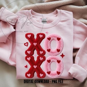 Op de afbeelding: Een lichtroze sweatshirt met de letters "XO" in een pluizig, getextureerd ontwerp. De "X"'en zijn rood met roze hartjes, en de "O"'s zijn roze met rode hartjes. De tekst "DIGITAL DOWNLOAD - PNG FILE" staat onderaan.