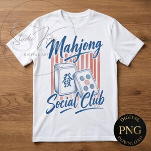 Peut inclure: Un t-shirt blanc à manches courtes avec une impression graphique portant le texte Mahjong Social Club en écriture bleue. Le motif comprend deux tuiles de mah-jong, l'une avec un caractère bleu et l'autre avec des cercles rouges et bleus.