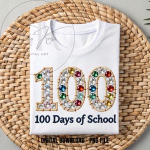 May include: White t-shirt with the number "100" embroidered with colorful gems and the text "100 Days of School". The shirt is displayed on a woven wicker basket.
