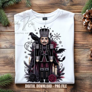 May include: White t-shirt with a gothic-themed nutcracker design. The illustration includes a crowned nutcracker, black roses, bats, and snowflakes. The text "DIGITAL DOWNLOAD - PNG FILE" is visible.