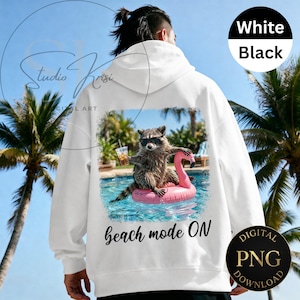 May include: White hoodie with a graphic of a raccoon wearing sunglasses and floating on a pink flamingo in a pool. The text "beach mode ON" is below the graphic. Digital PNG download.