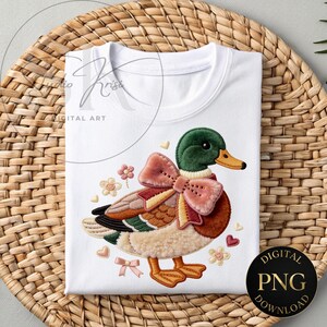May include: White t-shirt featuring an embroidered duck design with a green head, orange beak, and a large pink bow. The duck has brown, tan, and cream-colored feathers. The shirt has the text "DIGITAL PNG DOWNLOAD" on a black circle.