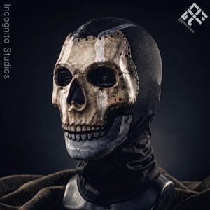 May include: A skull mask with a black hood. The mask is painted in a realistic style with a bone-colored skull and dark eye sockets. The mask has a stitched design and is set against a dark background.