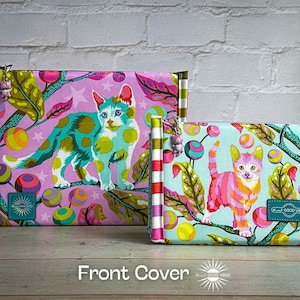 May include: Two zippered pouches featuring cat designs. The larger pouch has a pink background with a teal and green spotted cat. The smaller pouch has a teal background with a pink and orange striped cat. Both have striped edges.
