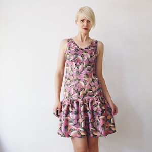 May include: A sleeveless pink and green floral print dress with a ruffled hem.