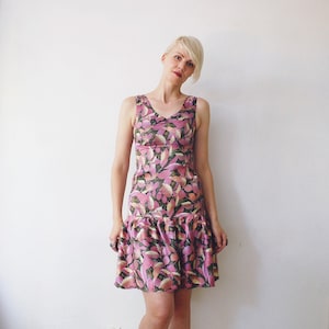 May include: A sleeveless pink and green floral print dress with a ruffled hem.