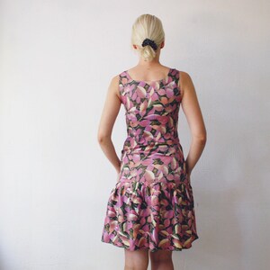 May include: A sleeveless pink and green floral print dress with a ruffled hem.