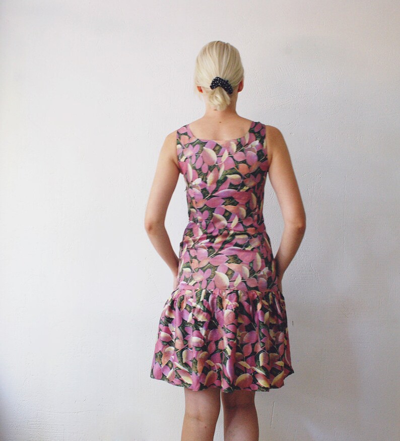 May include: A sleeveless pink and green floral print dress with a ruffled hem.