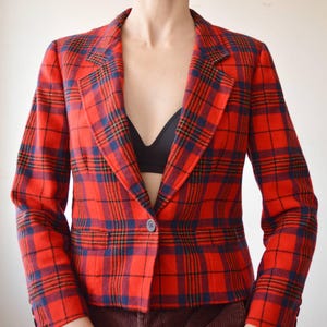 May include: A red, blue and yellow plaid blazer with a single button fastening.