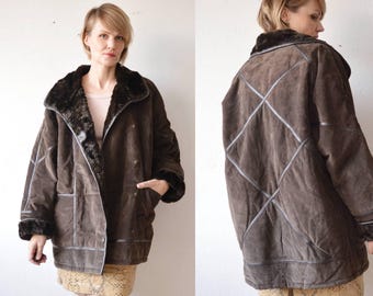 May include: A brown suede jacket with a faux fur collar and a diamond-shaped stitching pattern. The jacket has a zipper closure and two pockets.