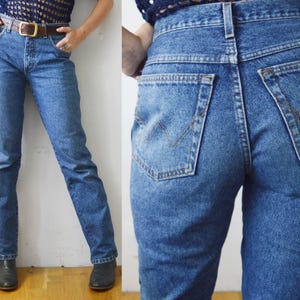 May include: A pair of high-waisted blue denim jeans with a classic straight leg fit. The jeans have a light wash and are made of a soft, comfortable denim.