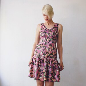May include: A sleeveless pink and green floral print dress with a ruffled hem.