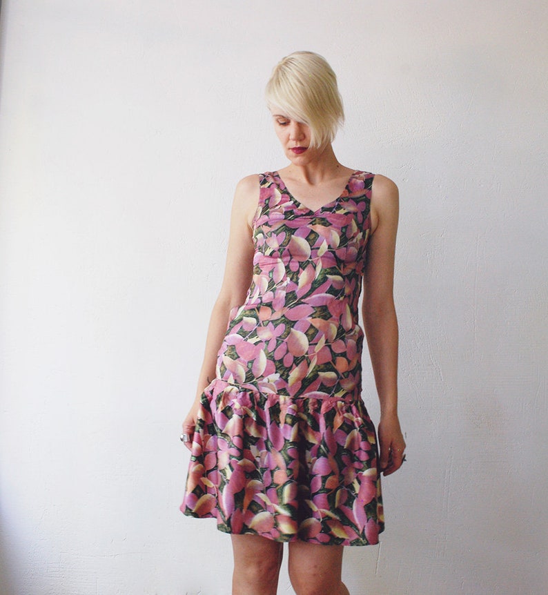 May include: A sleeveless pink and green floral print dress with a ruffled hem.