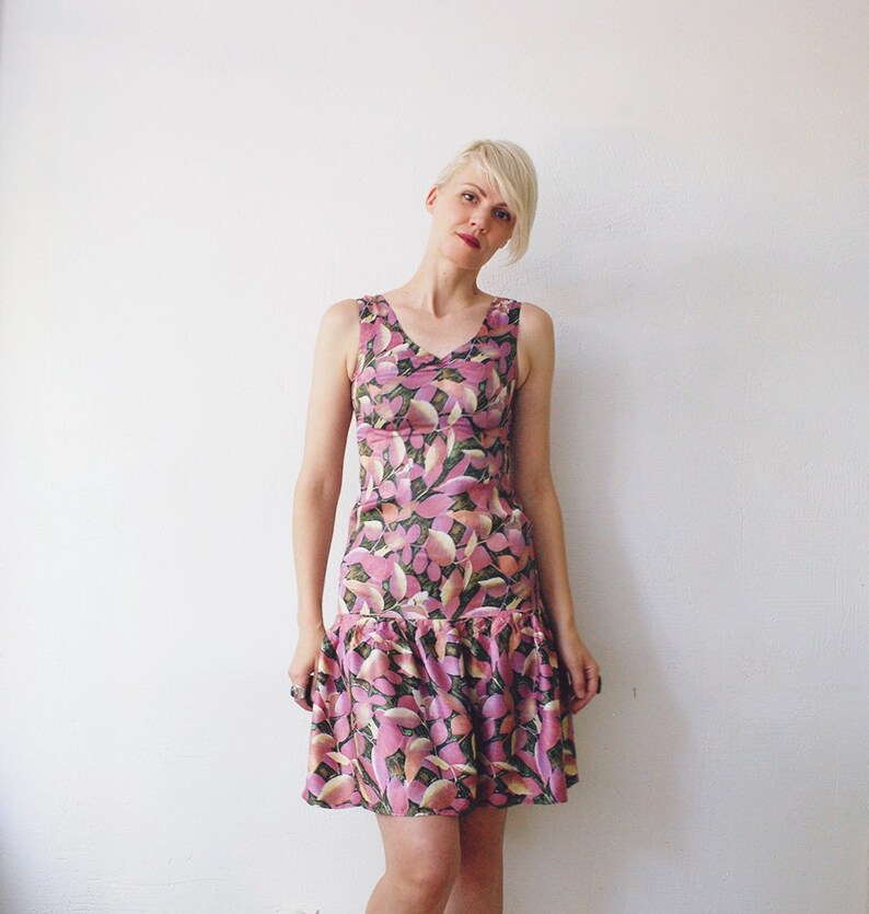 May include: A sleeveless pink and green floral print dress with a ruffled hem.