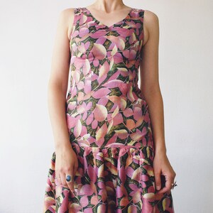 May include: A sleeveless pink and green floral print dress with a ruffled hem.