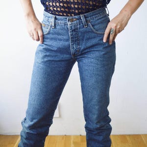 May include: A pair of blue denim jeans with a high waist and a straight leg.
