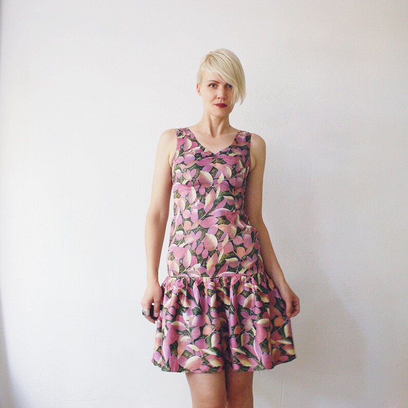 May include: A sleeveless pink and green floral print dress with a ruffled hem.