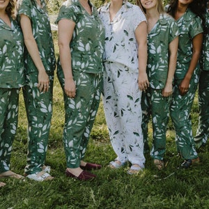 Puede incluir: Un grupo de personas que llevan pijamas a juego de color verde y blanco con diseños de hojas. Los pijamas tienen mangas cortas y pantalones largos.